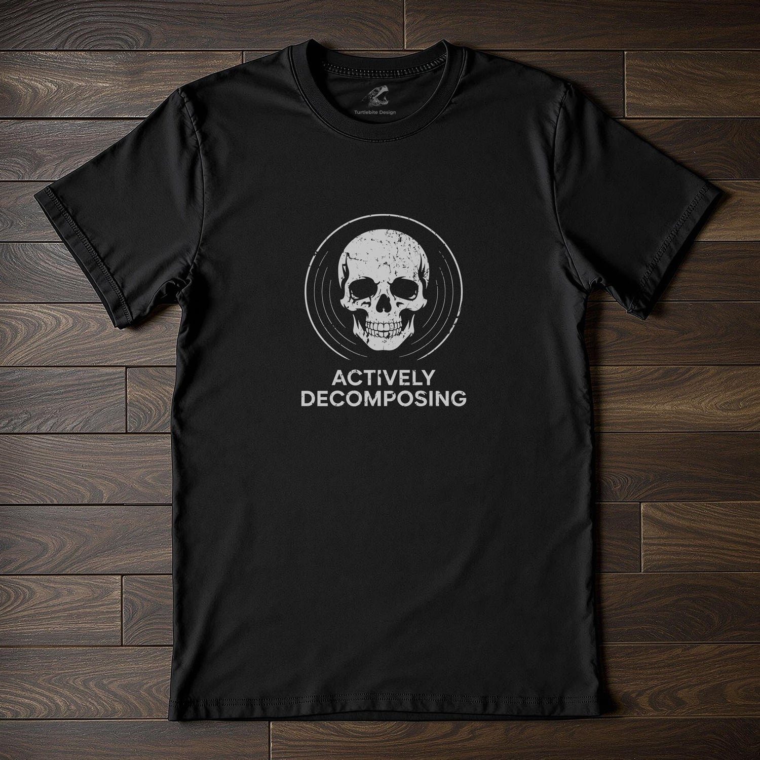 Black t-shirt with white skull graphic and "Actively Decomposing" text for dark humor fashion